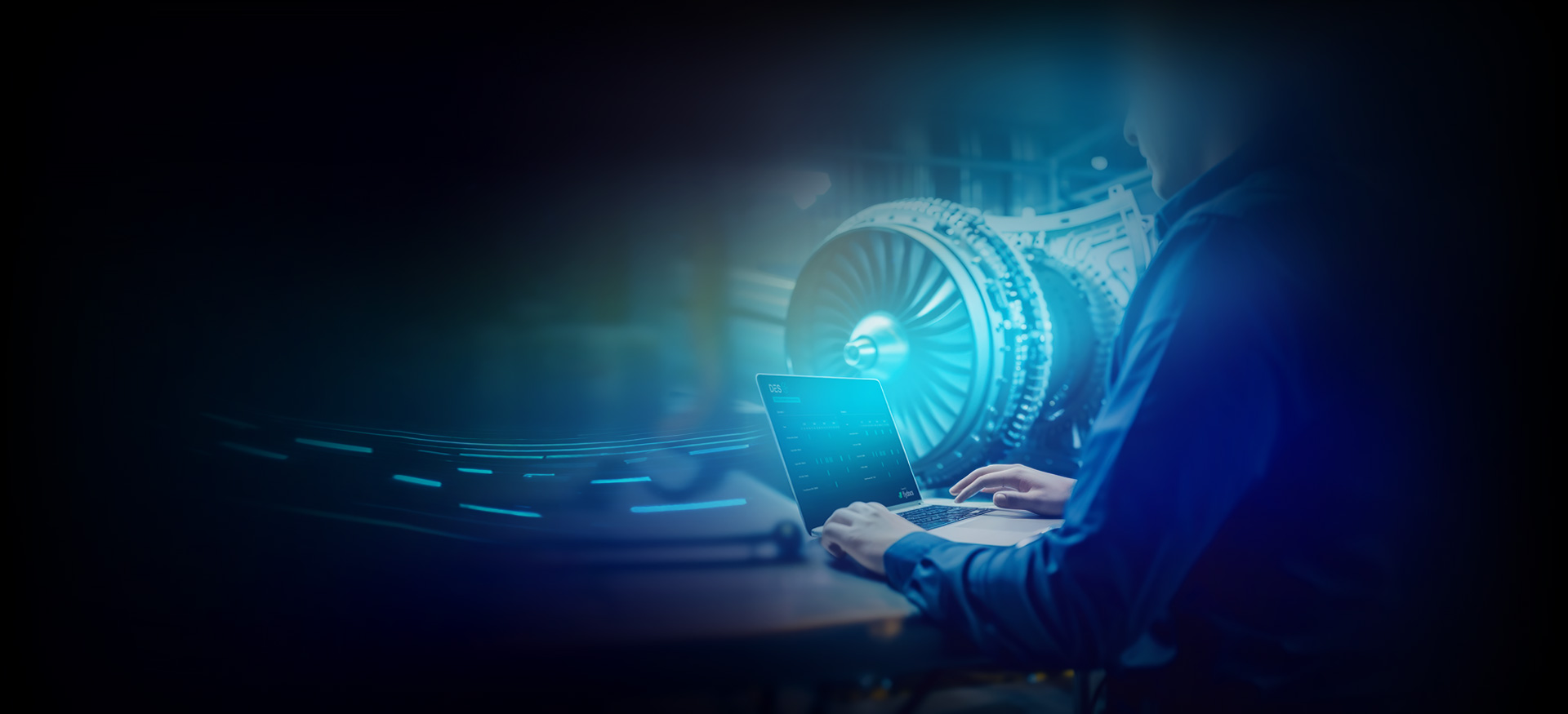 Person using laptop to analyse aircraft engineering data inside hangar