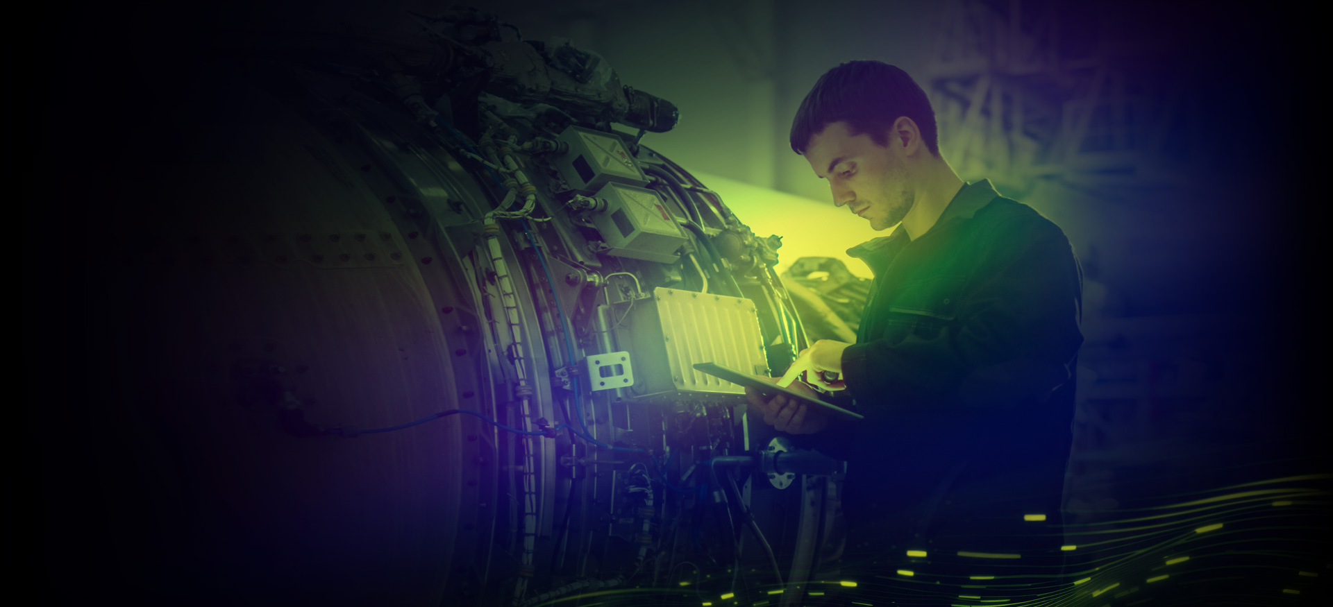 Technician using tablet to inspect aircraft engine in maintenance facility