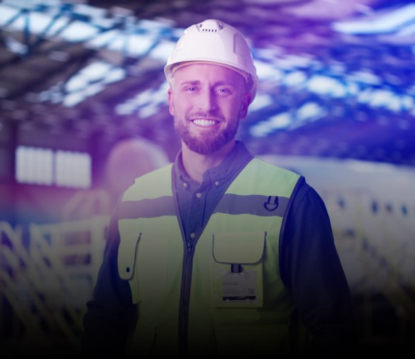 Worker wearing hard hat and high-visibility vest in aircraft hangar