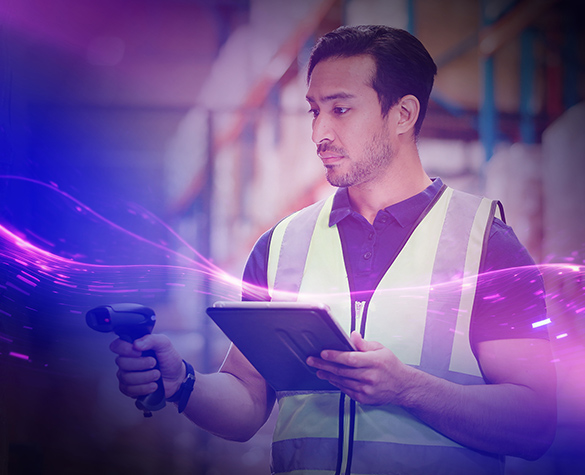 Warehouse worker scanning barcode with handheld device and tablet in storage aisle