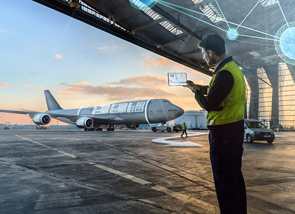 aircraft in hanger with man holding up digital application on a mobile device to show digital fleet capability