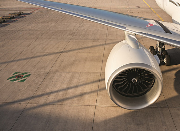 Aircraft engine and wing on tarmac with landing gear visible