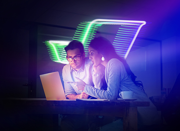 Two professionals collaborating over laptop with flydocs logo in neon lights in office in the background