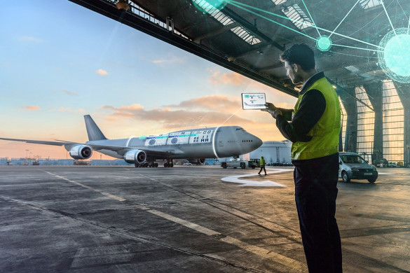 engineer inspecting aircraft in hangar and checking digital documentation to ensure aircraft is airworthy and all checks are in place